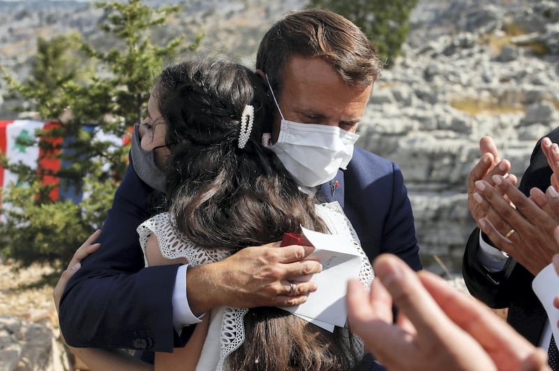 French President Emmanuel Macron hugs blast victim Tamara Tayah as he attends a ceremony to plant a cedar with members of the NGO Jouzour Loubnan in Jaj, near Beirut, Lebanon September 1, 2020. REUTERS/Gonzalo Fuentes/Pool