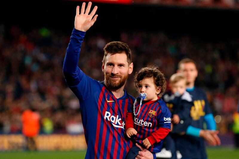 Lionel Messi holds his son Ciro as he celebrates after Barcelona won their 26th La Liga title. AFP