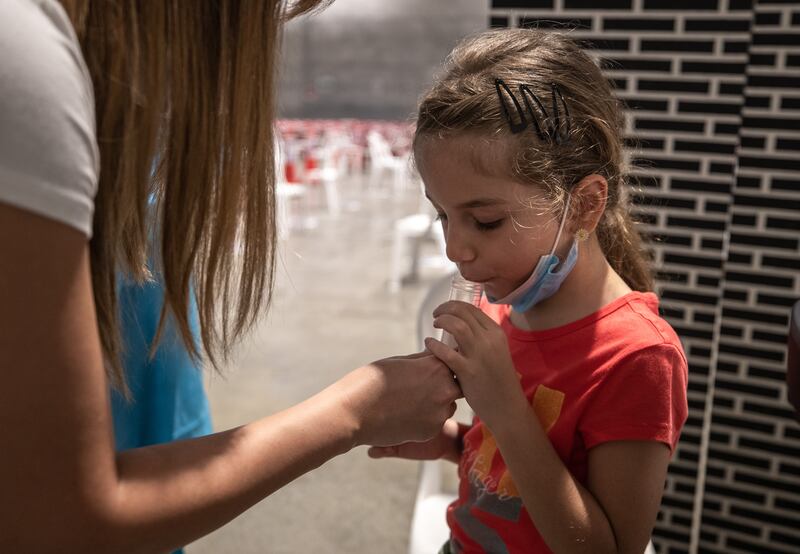 A young Abu Dhabi resident gives a saliva sample. 