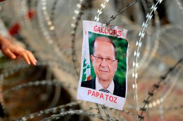 A picture of Lebanese President Michel Aoun above the message father of nothing hangs on barbed wire on the road leading to the Presidential Palace in Baabda. AFP