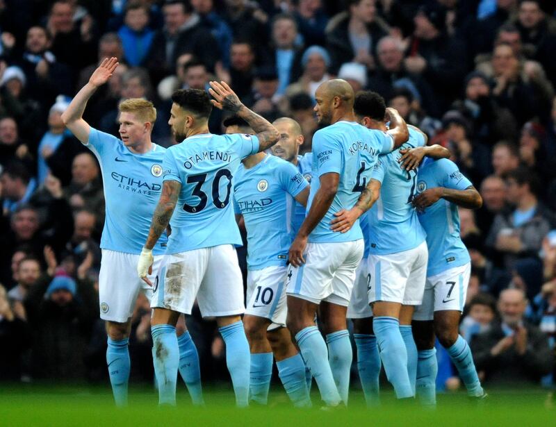 Manchester City's players celebrate after Manchester City's Sergio Aguero, obscured, scored his side's first goal during the English Premier League soccer match between Manchester City and Bournemouth at Etihad stadium, in Manchester, England, Saturday, Dec. 23, 2017. (AP Photo/Rui Vieira)