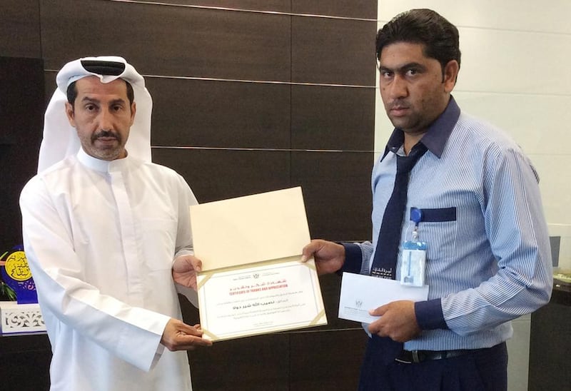Pakistani driver Naseerallah Sher Dola is presented with a certificate of gratitude for returning Dh1.7m that he found in his taxi. Courtesy Sharjah RTA 