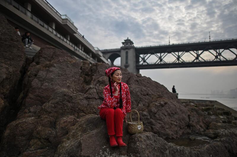 A woman poses for a photo on the bank of the Yangtze River in Wuhan, in China's central Hubei province. AFP