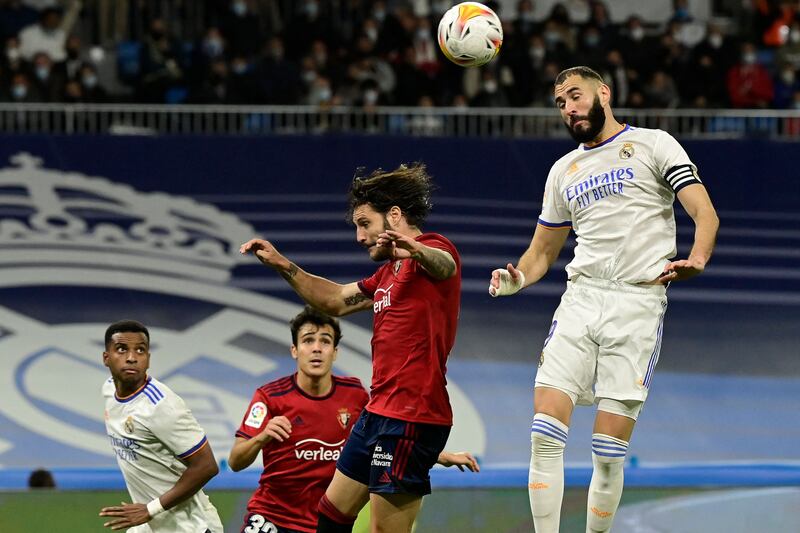 Osasuna's Spanish defender Juan Cruz and Real Madrid's French forward Karim Benzema jump for the ball. AFP