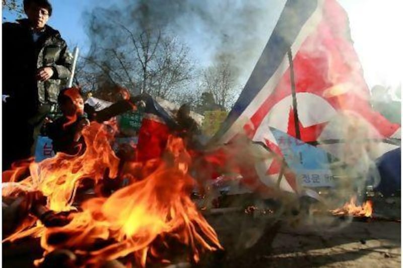 North Korean defectors burn the North Korean flag yesterday in front of the South Korean Defence Ministry in Seoul. Tensions remain high after an artillery exchange on Yeonpyeong island. Chung Sung-Jun / Getty Images