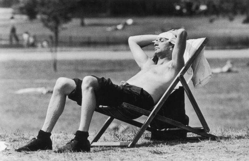 A Londoner sunbathing in Kensington Gardens with a knotted handkerchief protecting his head from the sunshine in 1976.