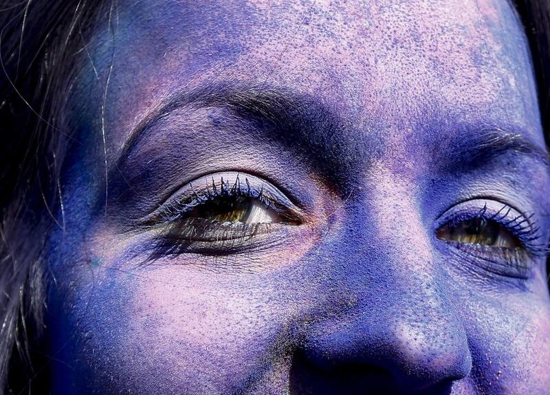 A female tourist with her face covered with coloured powder looks on during celebrations of the Holi Festival at Kathmandu Durbar Square, in Kathmandu, Nepal, Narendra Shrestha / EPA   