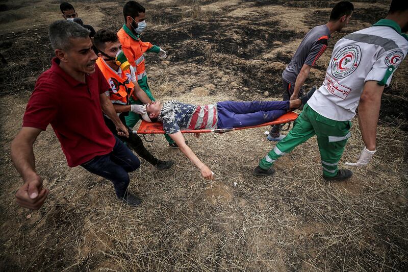 Palestinians medics carry a wounded protester during clashes after Friday protests near the border with Israel in eastern Gaza City. Mohammed Saber / EPA