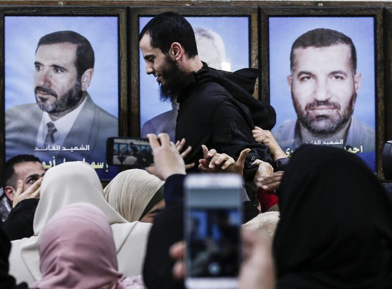 A member of the Palestinian Islamist Hamas movement is greeted by supporters before at the movement's leader Ismail Haniyeh's office in the Gaza Strip on February 28, 2019.  The Hamas leader announced in a press release today the release of four detainees from his group held in Egypt since August 2015.
 / AFP / MAHMUD HAMS
