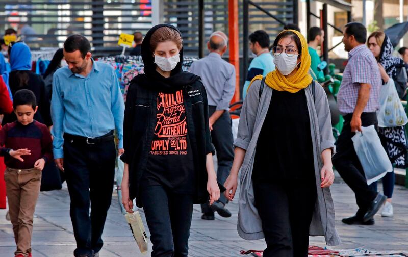 Iranians, some wearing face masks, walk along a street in the capital Tehran on June 3, 2020, amid the novel coronavirus pandemic crisis.  The spread of novel coronavirus has accelerated again this month in Iran which today officially confirmed over 3,000 new cases for a third consecutive day. / AFP / afp / -
