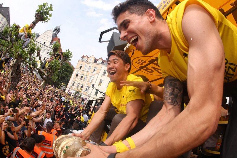 Dortmund's Marc Bartra, right, and Shinji Kagawa celebrate the club's German Cup victory with fans on May 28, 2017. Ina Fassbender / AFP