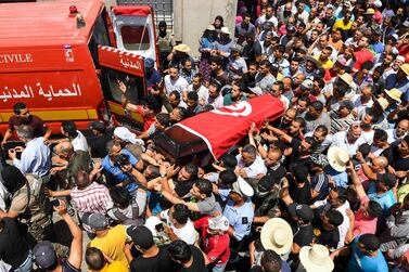 Mourners carry the coffin of killed Sgt Arbi Guizani, one of six security Tunisian officers killed on Sunday, at his funeral in Tunis on July 9, 2018. Fethi Belaid / AFP