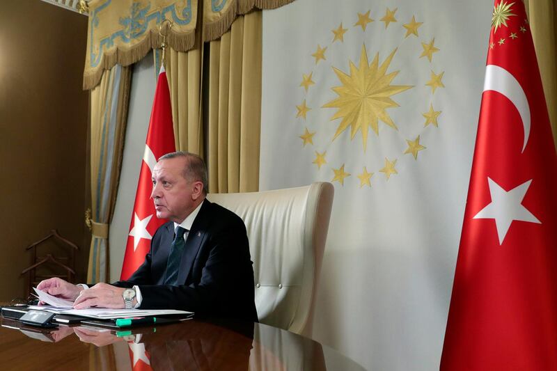 Turkish President Recep Tayyip Erdogan participates in a teleconference with European leaders, in Istanbul, Tuesday, March 17, 2020.Erdogan has discussed "opportunities for joint action" against the new coronavirus outbreak in a teleconference with the leaders of France, Germany and Britain, his office said Tuesday. The teleconference between Erdogan, German Chancellor Angela Merkel, French President Emmanuel Macron and British Prime Minister Boris Johnson was arranged after the European leaders cancelled plans to travel to Istanbul over the coronavirus crisis.(Presidential Press Service via AP, Pool)
