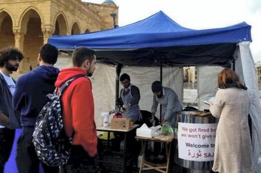 Roudy Hanna and Mark Darido serve customers at the saj stand they set up in downtown Beirut after being fired from their jobs. Courtesy Mark Darido.