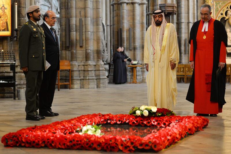 Emirati President Sheikh Khalifa bin Zayed al-Nahayan (2R) lays a wreath on the tomb of the Unknown Warrior as Dean of Westminster John Hall looks on (R) in Westminster Abbey in central London on May 1, 2013 on the second day of his state visit to Britain. The UAE president was to face questions from Prime Minister David Cameron during a meeting over allegations that three British men jailed in Dubai were tortured. AFP PHOTO / BEN STANSALL
 *** Local Caption ***  027752-01-08.jpg