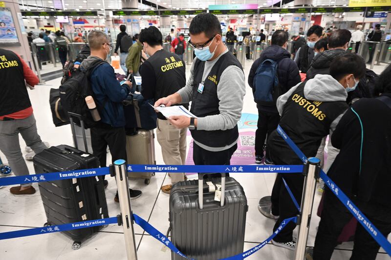 Customs officers check documents as people travel from Hong Kong, to mainland China.  AFP