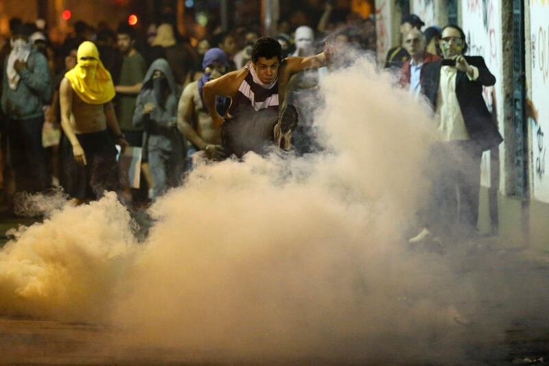 A protester kicks a gas canister during a demonstration a in Rio de Janeiro, Brazil, Monday, June 17, 2013.  Thousands took to the streets in largely peaceful protests in at least eight cities in Brazil Monday, demonstrations that voiced the deep frustrations Brazilians feel about carrying heavy tax burdens but receiving woeful returns in public education, health, security and transportation. Officers in Rio fired tear gas and rubber bullets when a group of protesters invaded the state legislative assembly and later vandalized and looted properties in the area.(AP Photo/Victor R. Caivano) *** Local Caption ***  Brazil Confed Cup Protest.JPEG-035b3.jpg