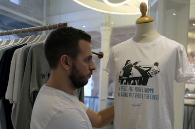 A salesman places a parodic t-shirt reading "A small step for the man, a giant step towards retirement" (Un petit Pat pour l'homme, un grand Pat pour la retraite) on a plastic dummy in Marseille on November 4, 2017.
A Marseille clothing designer is hoping to make hay with a hastily-designed t-shirt mocking Patrice Evra's karate kick on one of his team's own fans. The caption, a play on words with 'Pat' and 'pas' (step) evokes American astronaut Neil Armstrong's iconic message back to earth when he became the first man to step on the moon in 1969. / AFP PHOTO / BORIS HORVAT