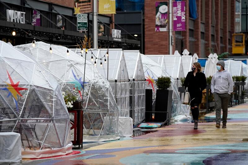 People walk by outdoor plastic dining bubbles on Fulton Market in Chicago. Colder temperatures are providing a new challenge for restaurants during the coronavirus pandemic, but there's a solution being developed in Fulton Market. AP Photo