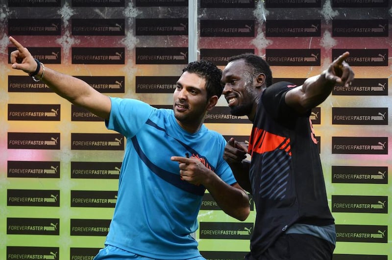 Yuvraj Singh and Usain Bolt pose for a picture after their exhibition in front of fans in Bangalore on Tuesday. Manjunath Kiran / AFP