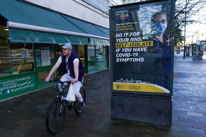 A cyclist rides past a billboard in Hull, UK. Getty