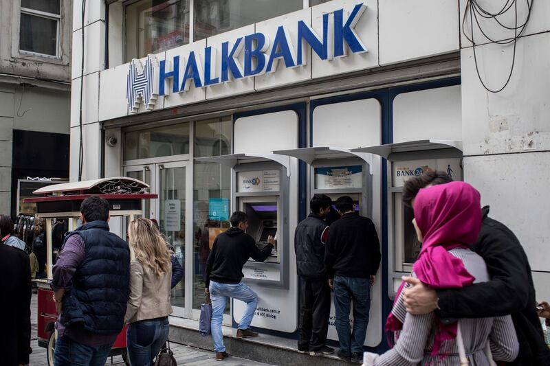 ISTANBUL, TURKEY - DECEMBER 01: People walk past a branch of Turkish bank HalkBank on December 1, 2017 in Istanbul, Turkey. The trial of Mr. Reza Zarrab, an Iranian-Turk who ran a foreign exchange and gold dealership continues in New York. In recent days testimony Mr. Zarrab implicated a number of Turkish Banks as well as high ranking government officials. Mr. Zarrab is accused of managing a billion-dollar scheme to smuggle gold for Iranian oil and conspiring to violate United States sanctions against Iran. (Photo by Chris McGrath/Getty Images)