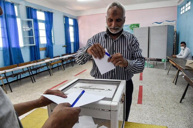 A man prepares to cast his ballot at a polling station in Bouchaoui, on the western outskirts of Algeria's capital Algiers, on June 12, 2021 during the 2021 parliamentary elections. Polls opened in Algeria for a parliamentary election overshadowed by a crackdown on a long-running protest movement that has campaigned for a mass boycott. Pro-government parties have urged a big turnout for the "crucial vote" which they hope will restore stability after two years of turmoil since the forced resignation of veteran president Abdelaziz Bouteflika. / AFP / RYAD KRAMDI                        
