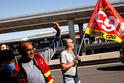Strikers demonstrate outside a terminal on Friday at Roissy Airport, north of Paris. AP