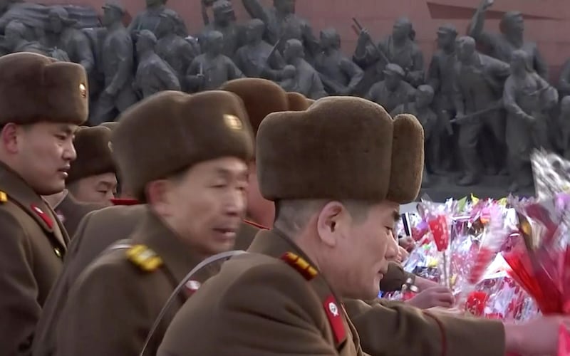 North Korean military personnel lay flowers in front of giant statues of Kim Il Sung and Kim Jong Il on Mansu Hill in central Pyongyang, KRT / AP