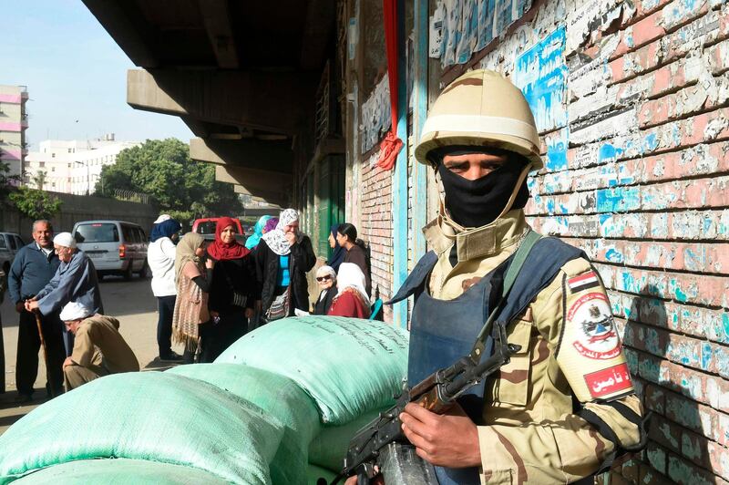 An Egyptian army soldier stands guard as voters queue up outside a polling station before the start of the first day of the 2018 presidential elections, in Boulaq al-Dakrour neighbourhood in the capital Cairo's southwestern Giza district on March 26, 2018. Khaled Desouki / AFP