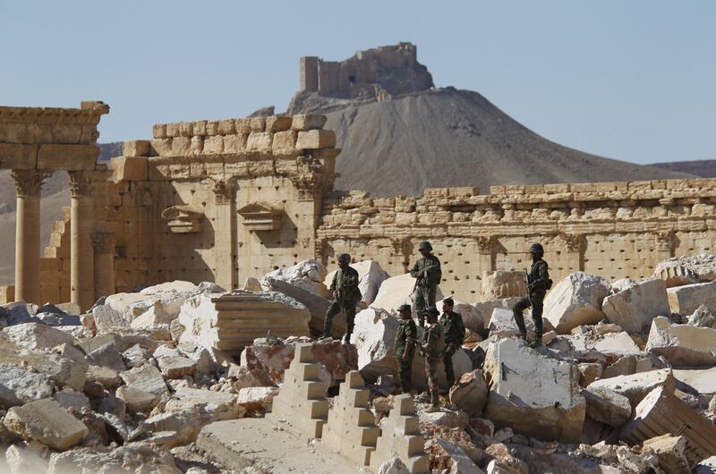 Syrian army soldiers stands on the ruins of the Temple of Bel in the historic city of Palmyra, in Homs Governorate, Syria April 1, 2016. The Fakhreddin's Castle is seen in the background. REUTERS/Omar Sanadiki      TPX IMAGES OF THE DAY     SEARCH "PALMYRA SANADIKI" FOR THIS STORY. SEARCH "THE WIDER IMAGE" FOR ALL STORIES