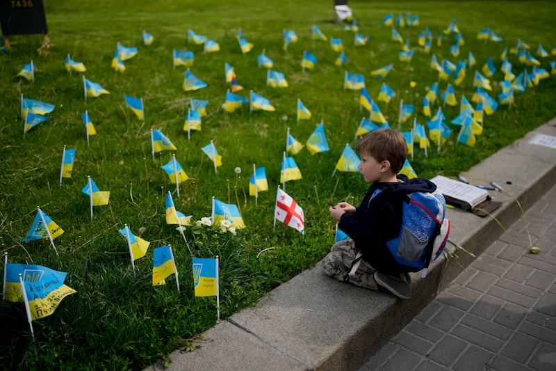 A boy looks at flags honouring soldiers killed while fighting Russian troops, in Kyiv city centre. AP 