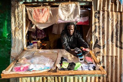 A man closes his business before the beginning of a curfew which was ordered by Kenyan President, Uhuru Kenyatta, to contain the spread of the COVID-19 coronavirus on March 27, 2020 in Kibera, Nairobi. Kenyan President Uhuru Kenyatta on March 25, 2020, ordered a nighttime curfew to curb the spread of the COVID-19 coronavirus, while taking a massive pay cut and unveiling tax breaks to ease the economic impact of the crisis on citizens. / AFP / patrick meinhardt
