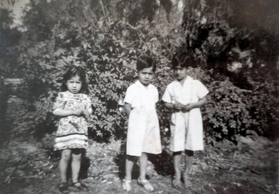 A young Lamees Ibrahim in front of her house in Baghdad with her brothers, Qais and Harith. Courtesy Lamees Ibrahim 