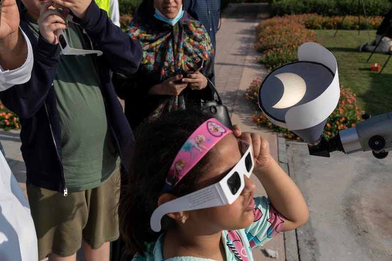 People gather at the Al Thuraya Astronomy Centre in Mushrif Park to watch the partial solar eclipse. Antonie Robertson/The National
