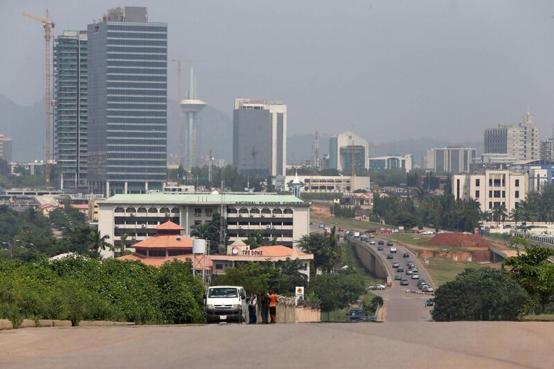 Commercial towers sit on the city skyline beyond a highway in Abuja, Nigeria, on Wednesday, Oct. 21, 2015. A drop in crude prices in the past year has put pressure on public finances, while the naira has declined 7 percent against the dollar this year. Photographer: George Osodi/Bloomberg