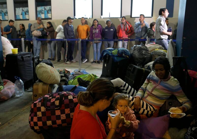 Venezuelan migrants rest while another group stands in line to enter am immigration office in Tumbes, Peru, Saturday, Aug. 25, 2018. Thousands of Venezuelans are crossing into Peru hours before authorities begin enforcing stiffer rules that will make entering the South American nation more difficult. (AP Photo/Martin Mejia)