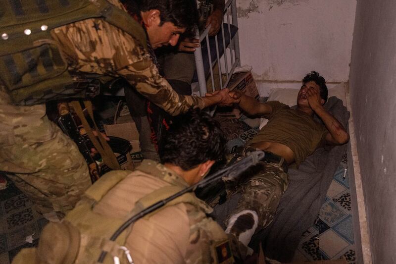 Afghan Special Forces tend to a soldier injured during a firefight with the Taliban during an attack on a district centre in Kandahar province, July 12, 2021.