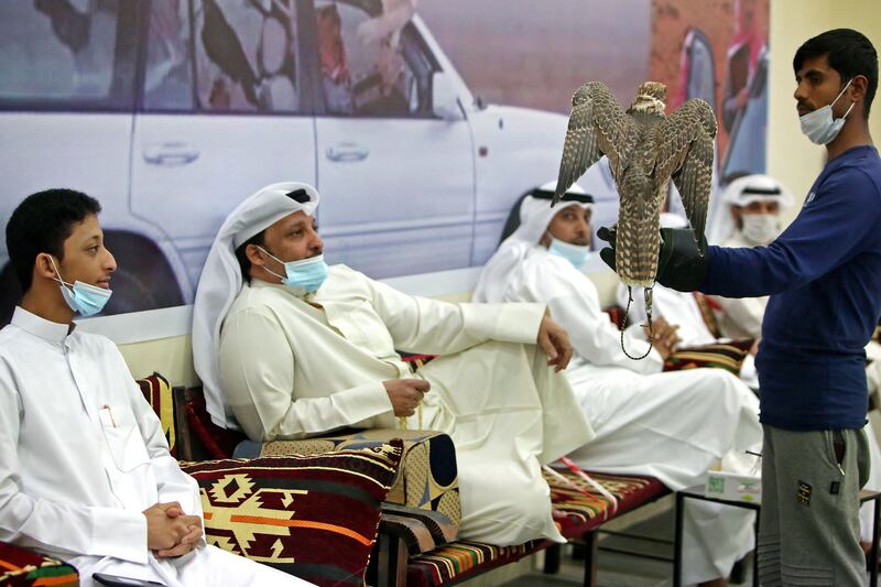 A falcon is shown by a worker at the auction.