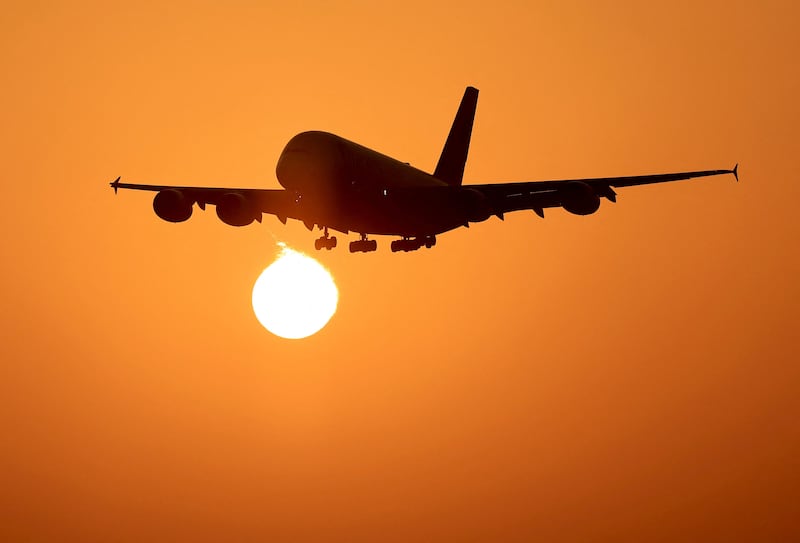 An Emirates plane lands at Dubai International Airport at sunrise. AFP