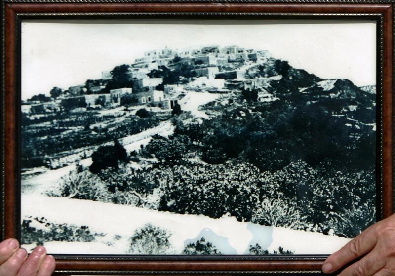 TO GO WITH STORY BY DJALLAL MALTI 
A photograph of the Palestinian village of Iqrit, Galilee, in 1937, a few years before Israeli forces forced an evacuation in 1948 during the creation of Israeli, shown by Maruf Achqar, 79, on July 19, 2009. AFP PHOTO /AHMAD GHARABLI (Photo by AHMAD GHARABLI / AFP)