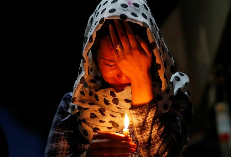 A woman cries as she holds a lit candle for the victims of the blast in Kabul on June 1, 2017. Mohammad Ismail / Reuters