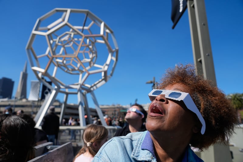 A woman watches the total solar eclipse outside the Exploratorium in San Francisco, California. AP