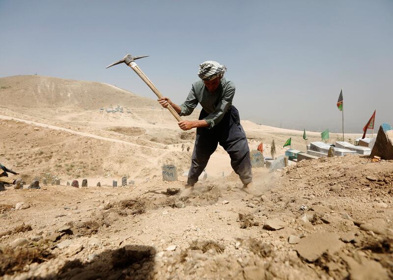 An Afghan man digs graves for the victims of yesterday's suicide attack in Kabul. Reuters
