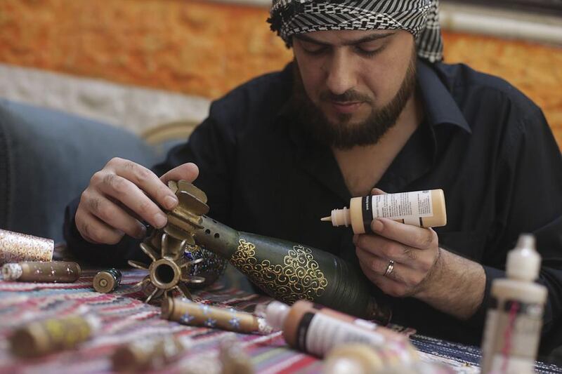 Akram Sweidan decorates on a mortar shell in the Duma neighbourhood of Damascus. Bassam Khabieh / Reuters