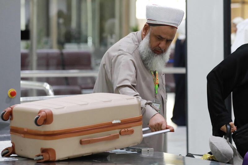 A pilgrim takes his luggage after inspection in Baghdad. AFP