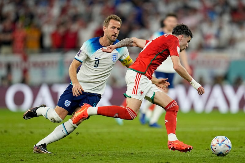 Wales's Neco Williams, right, gets away from Harry Kane. AP 