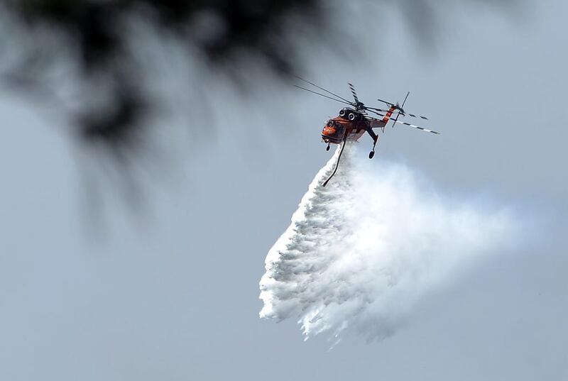 A helicopter drops water to douse bushfires along the Linksview Road near Faulconbridge in the Blue Mountains.  Saeed Khan / AFP