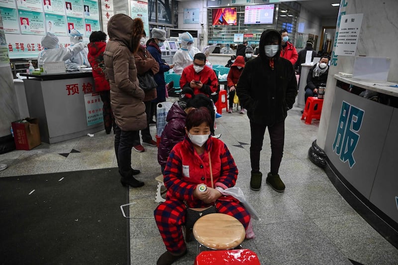 People wearing facemasks to help stop the spread of a deadly virus which began in the city, wait for medical attention at Wuhan Red Cross Hospital in Wuhan.  AFP