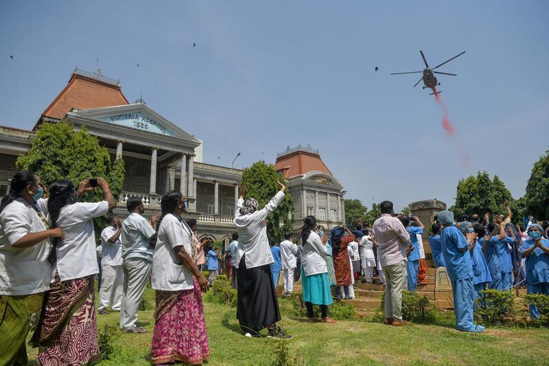 Medical staff cheer as an Indian Air Force Mi-17 helicopter drops flower petals over the Victoria Hospital in Bangalore. AFP